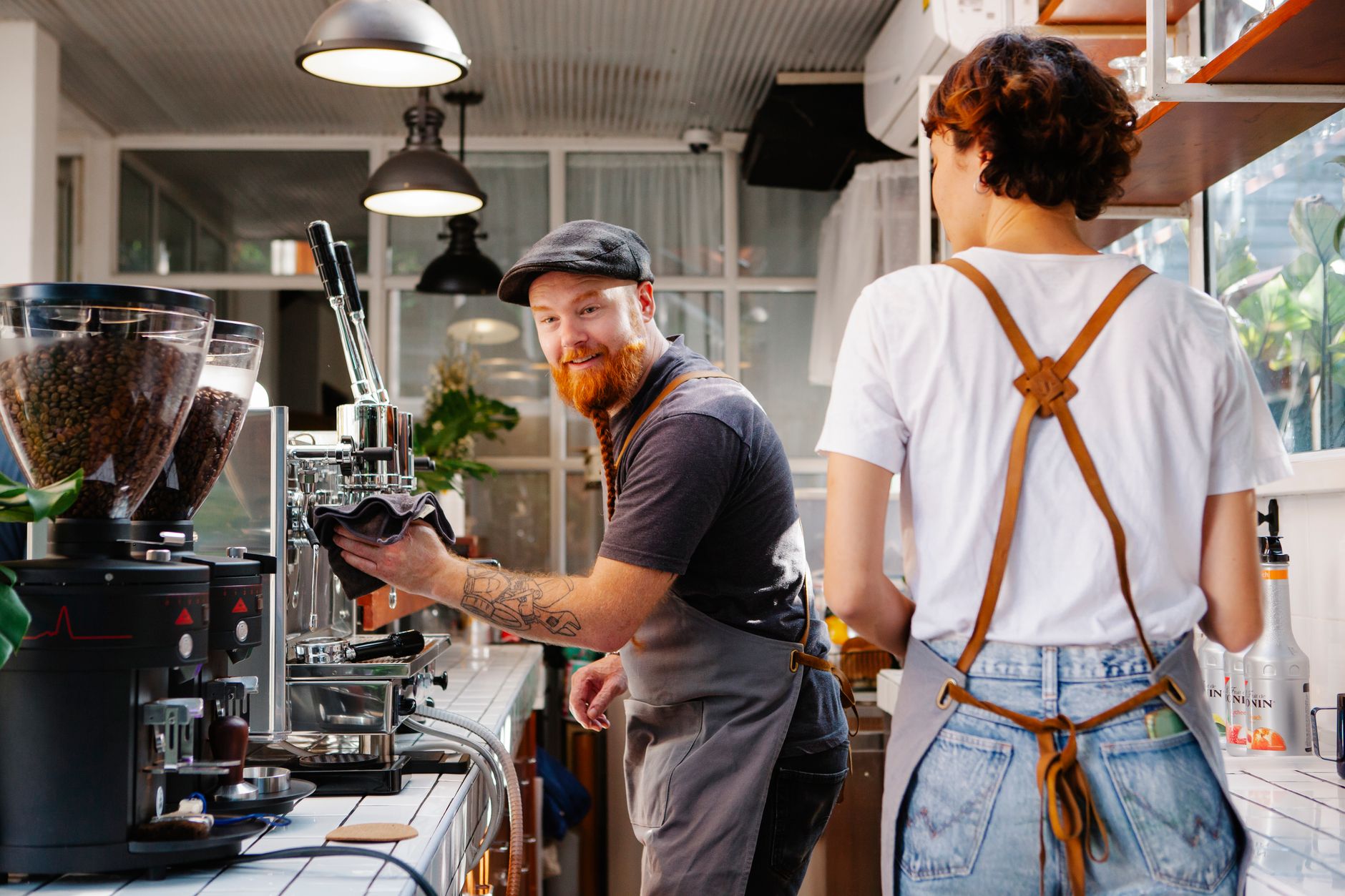 Barista’s aan het werk achter de espressobar van Koffie & Jij in warm cafésfeerlicht